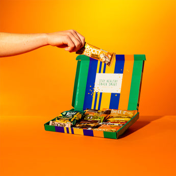 Particuliere box met gezonde tussendoortjes, waaronder Rocky en andere snacks.